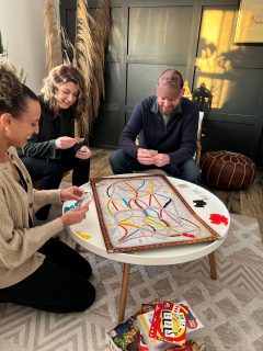 Group of three people playing board games in a living room